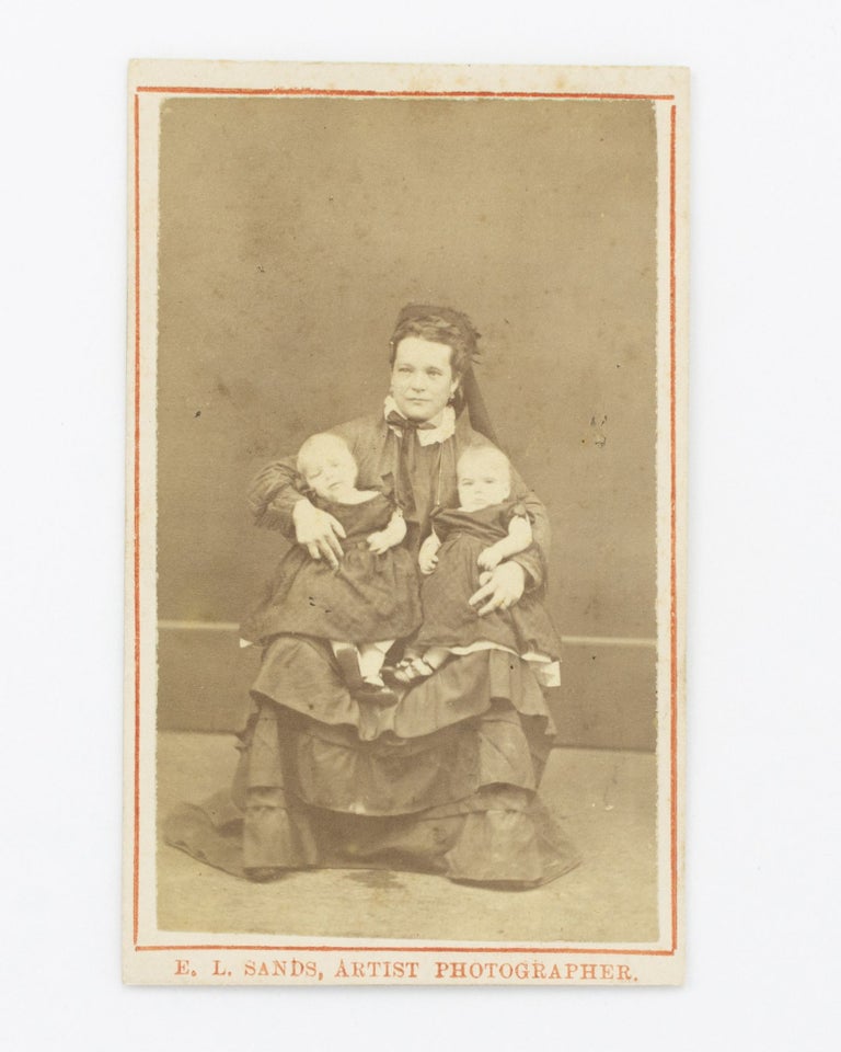 Item #102701 A carte de visite photograph of a young woman holding twin baby girls. Portrait of a. Mother, Twins.