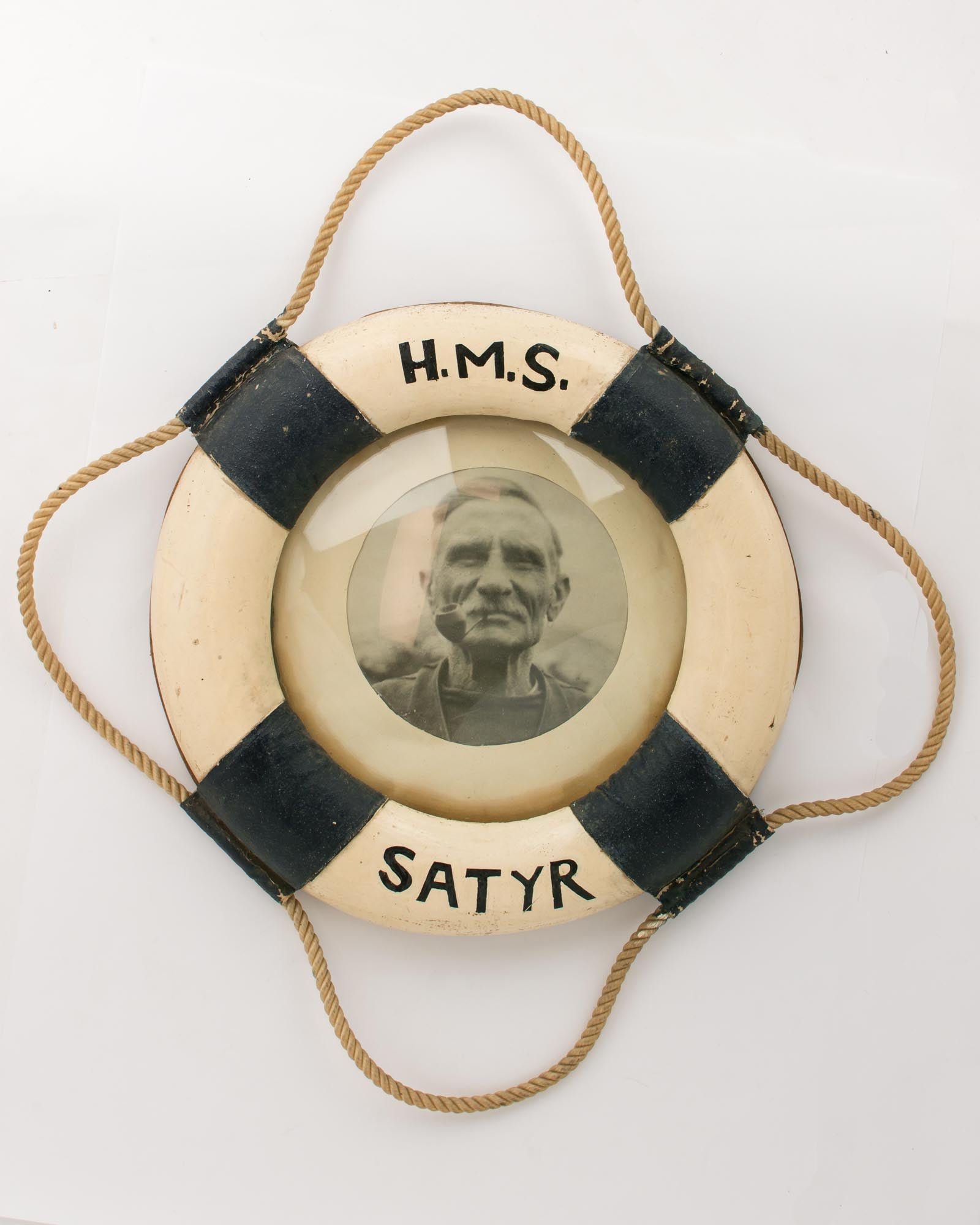 A portrait photograph of an old salt, framed in a small-format model of a  life buoy from HMS 'Satyr' HMS 'Satyr'