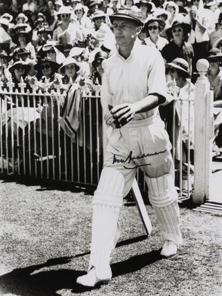 Item #114803 A signed photograph (black and white, 253 × 203 mm) of Don Bradman walking out to...