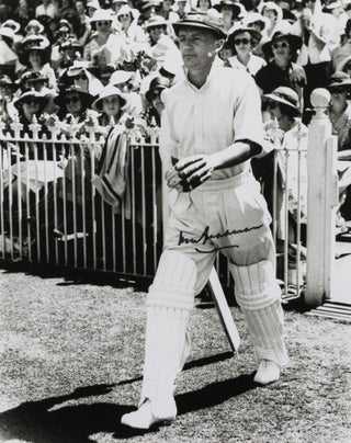 Item #114803 A signed photograph (black and white, 253 × 203 mm) of Don Bradman walking out to...