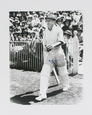 Item #114806 A signed photograph (black and white, 303 × 240 mm) of Don Bradman walking out to...