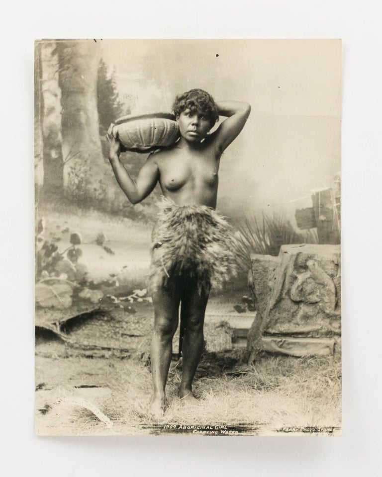 Item #123316 'Aboriginal Girl Carrying Water' [a studio tableau portrait photograph of an Indigenous woman wearing a fur 'apron' with a container on her right shoulder]. Indigenous Australian Portraiture.