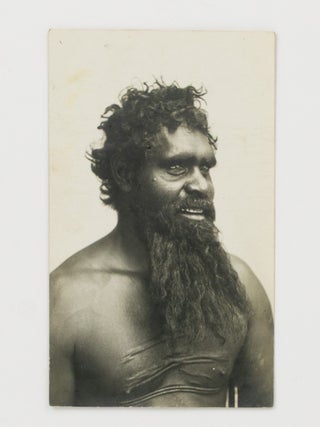 A large portrait photograph of a Central Australian Indigenous man with traditional scarification