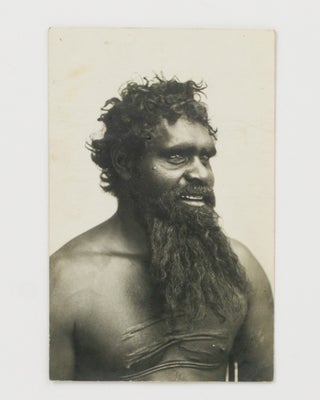 A large portrait photograph of a Central Australian Indigenous man with traditional scarification