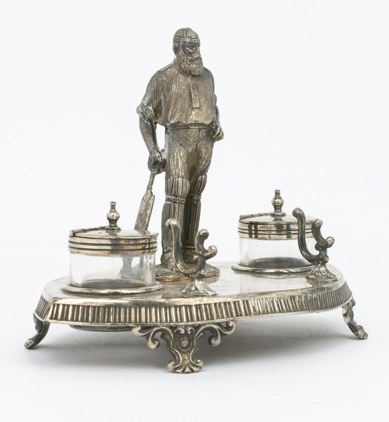Item #66237 A silver-plated standish - a desk set holding pens and ink - featuring a 120 mm-high figure of W.G. Grace as its centrepiece. Cricket, William Gilbert GRACE.